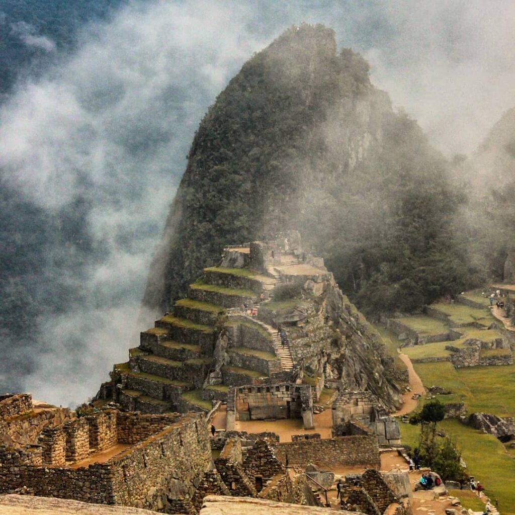 Intihuatana Stone in Machu Picchu city with clouds and rain 